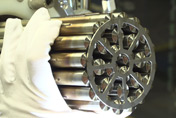 BWXT CANDU fuel bundle, manufactured by BWXT, being held by a white glove.