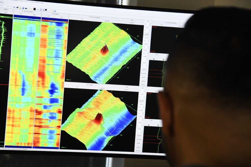 BWXT employee looking at waveform and heat map diagrams on a screen