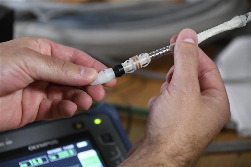BWXT employee holding a metallic component