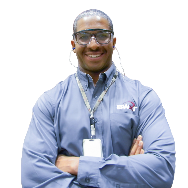 BWXT employee wearing safety glasses with arms crossed on a clear background