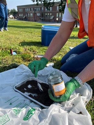 BWXT soil sampling employee taking samples in jar